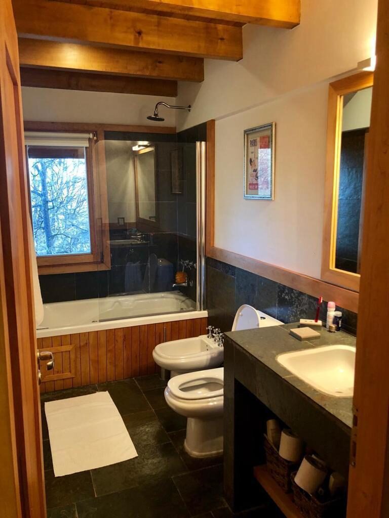 Baño con bañera y ventana al bosque nevado