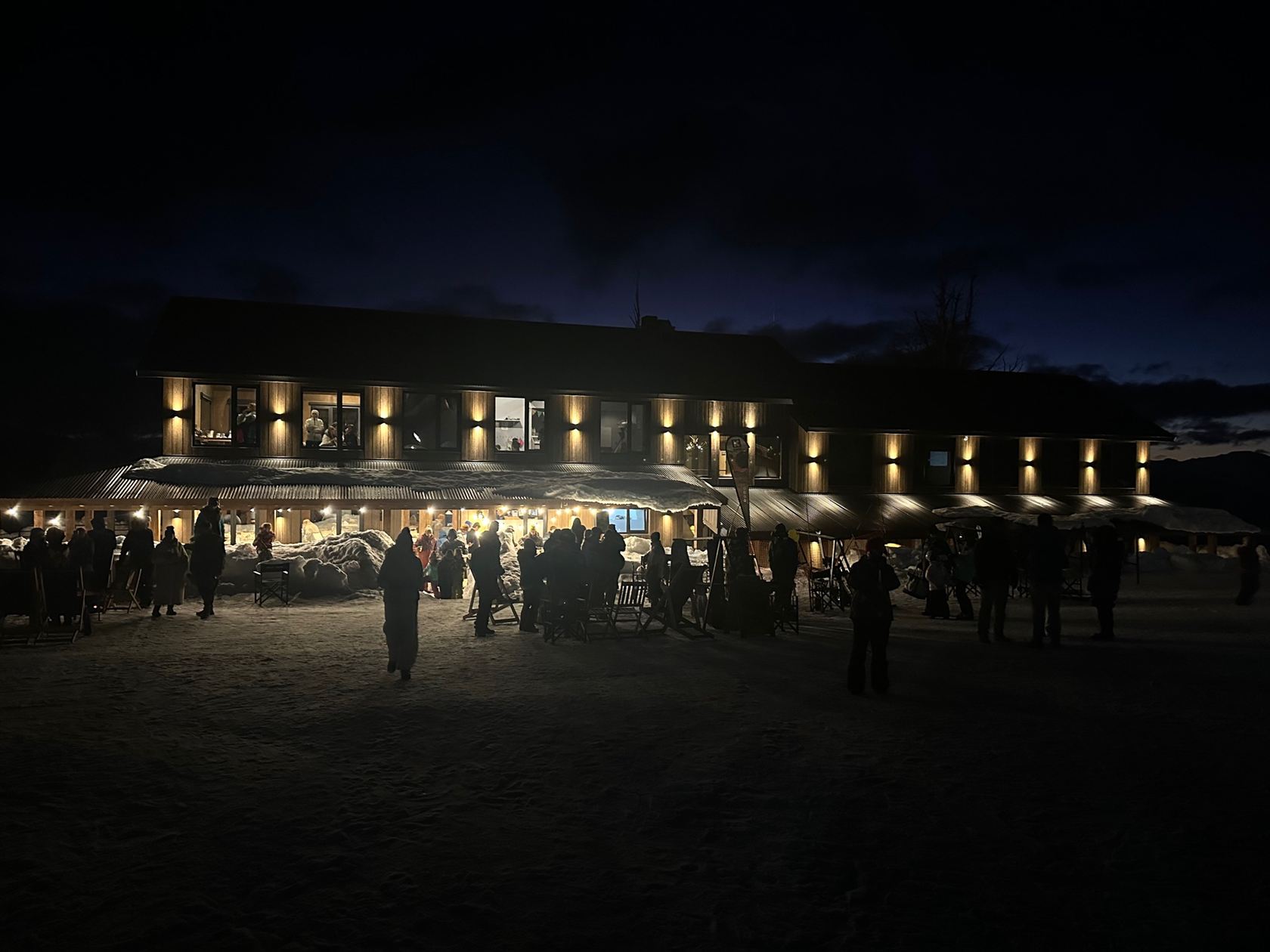 La base del barrio iluminada de noche, con la gente reunida