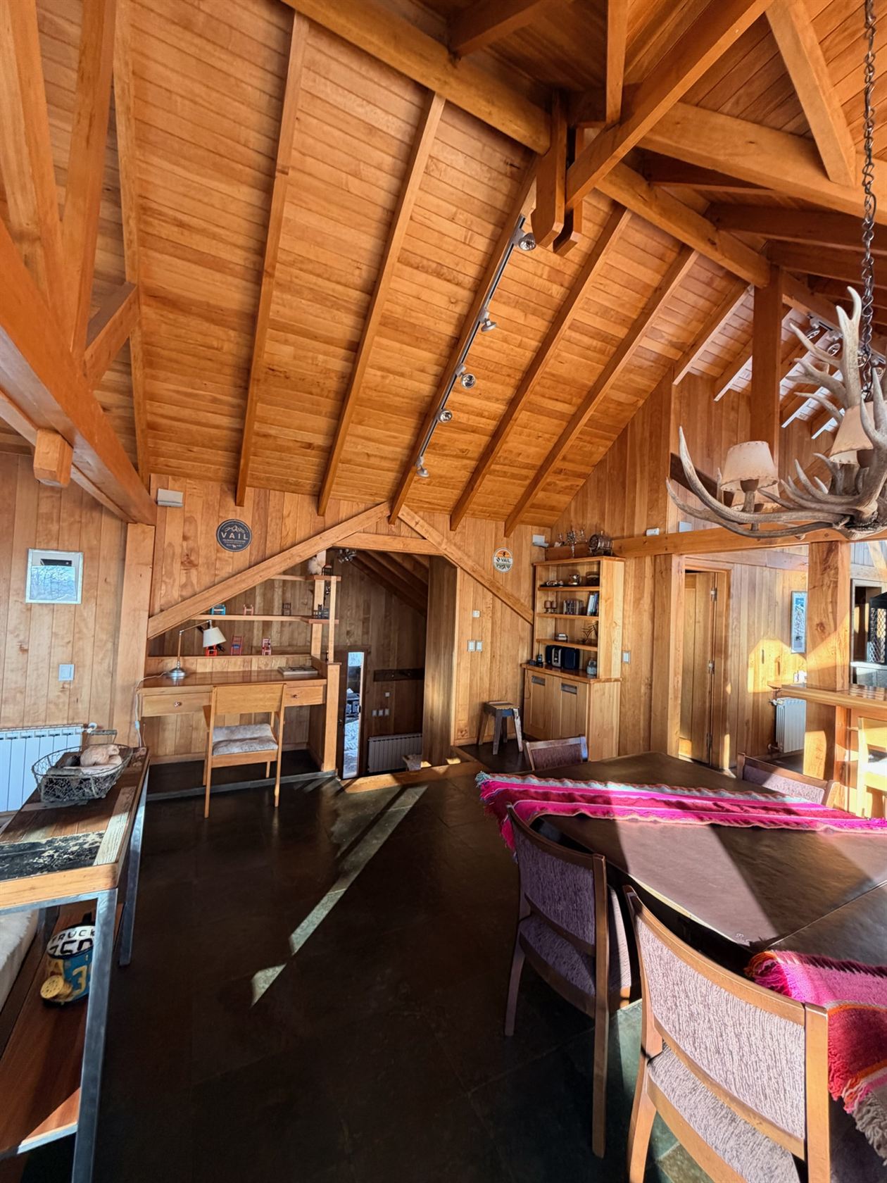 El comedor con su escritorio y la biblioteca, bajo el techo de madera