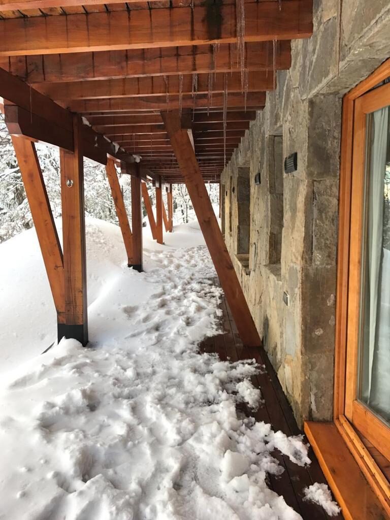 Galería cubierta de la cabaña con la nieve