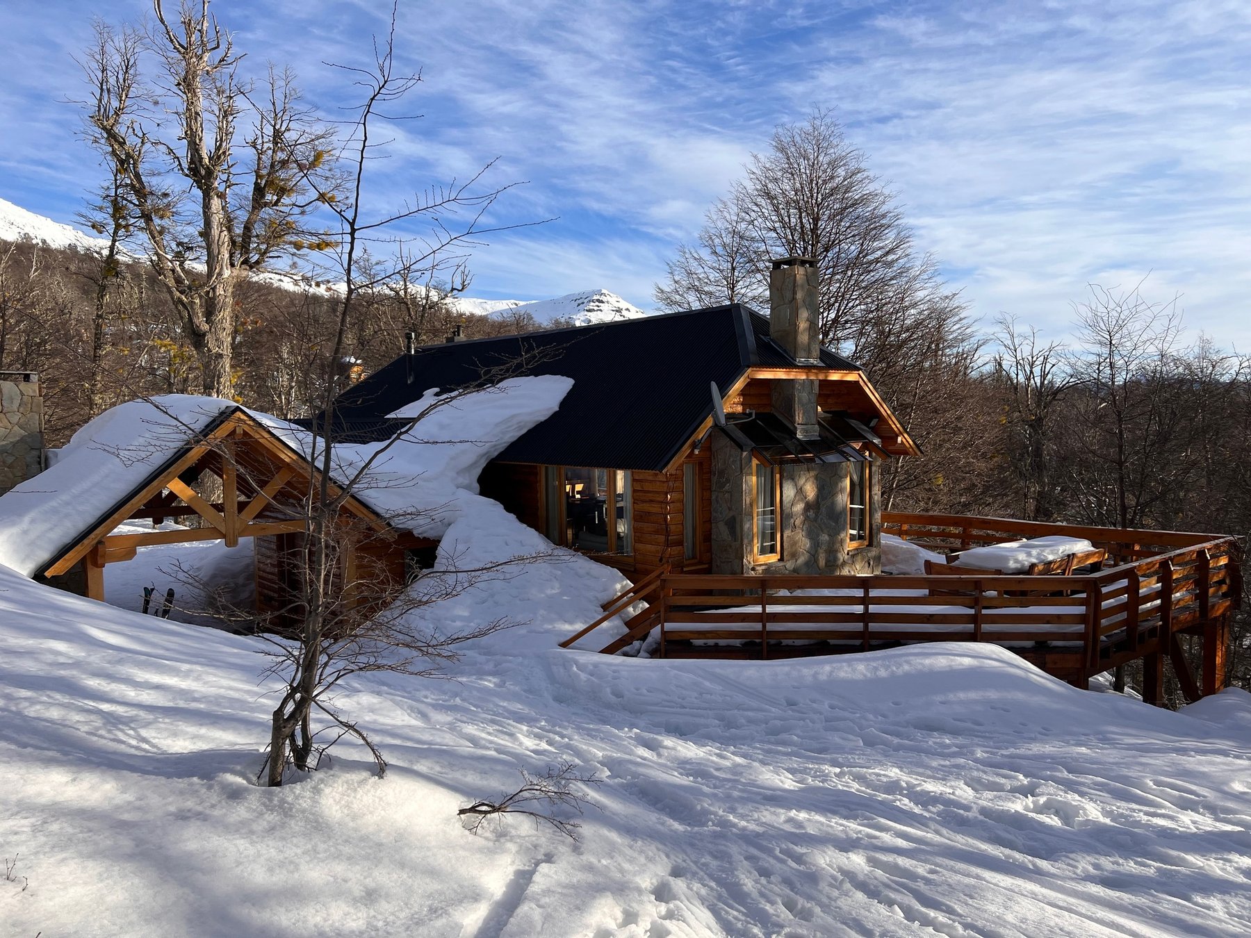 La cabaña hundida en la nieve, con la cordillera de fondo