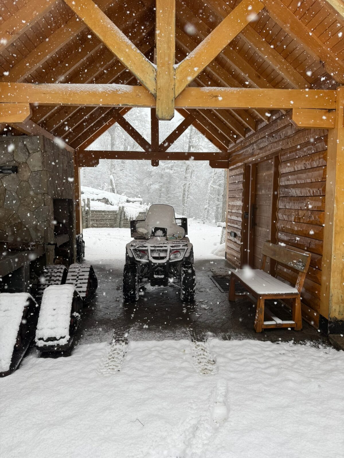 La cochera cubierta con el cuatriciclo de nieve