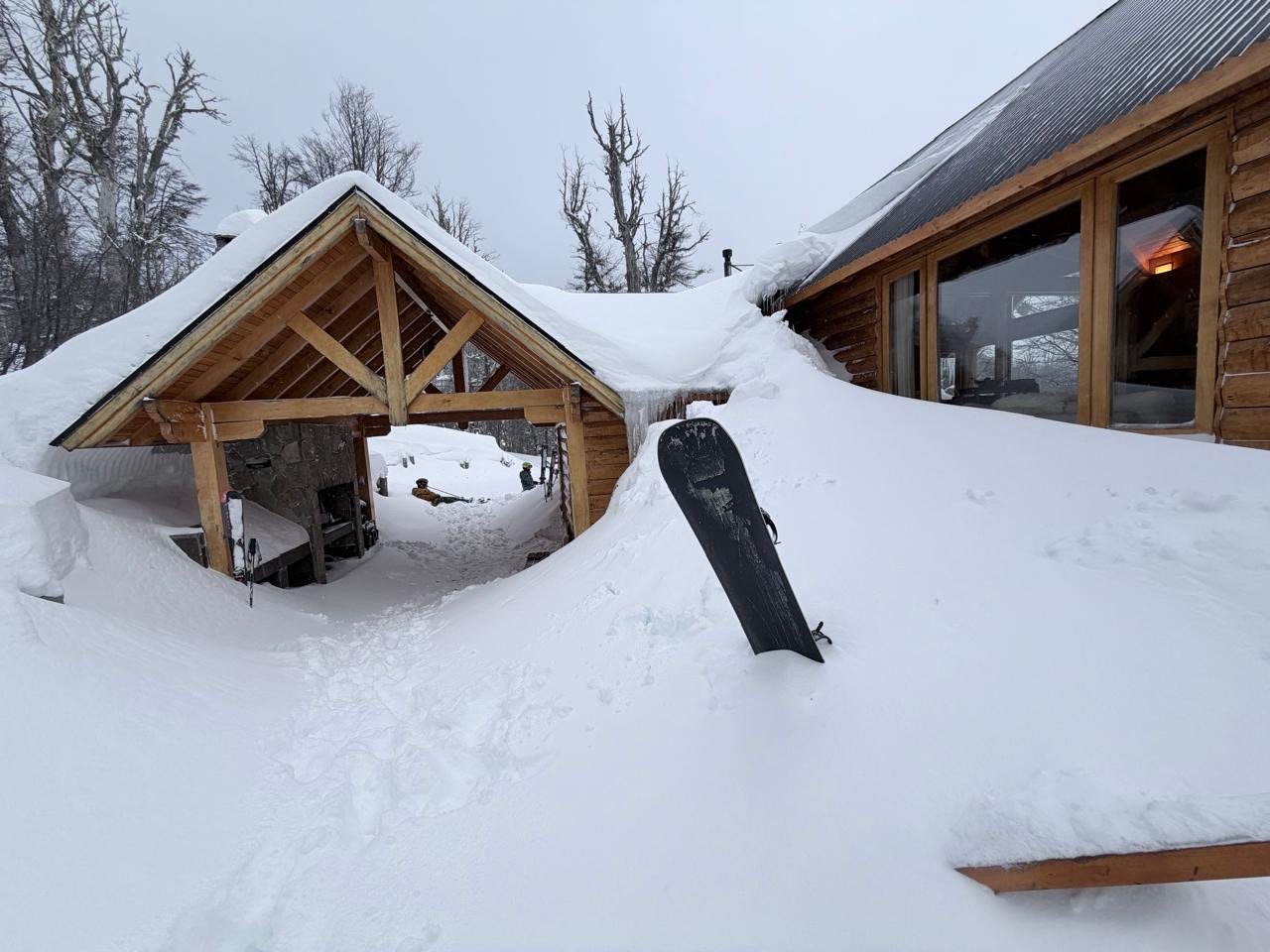 La nieve llegando al techo de la cochera, con el ventanal del living encendido