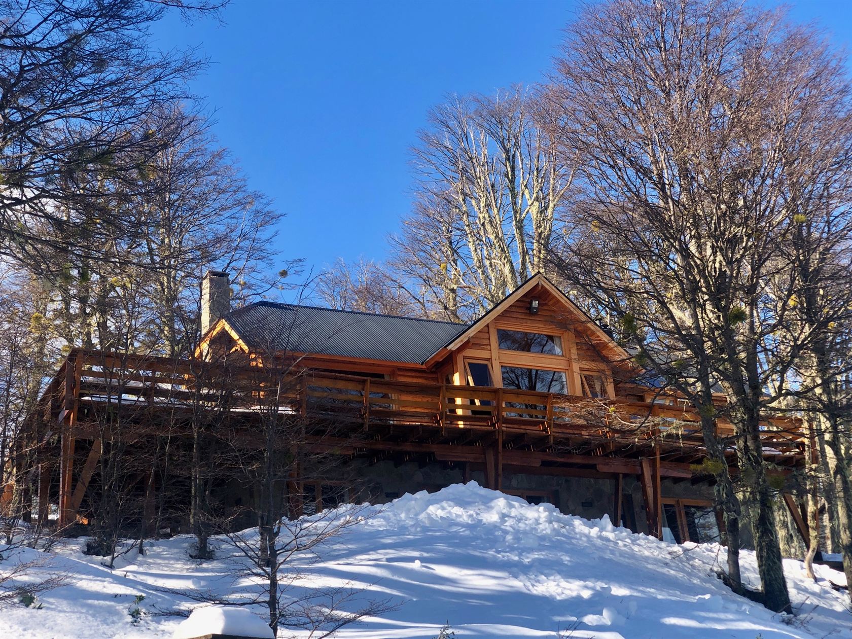 La casa vista desde abajo en un día de sol, con el deck elevado rodeándola