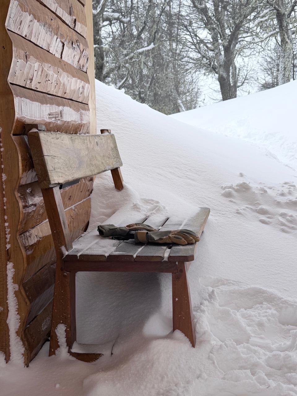 El banco de la entrada cubierta, con los guantes secándose y la nieve acumulada al costado