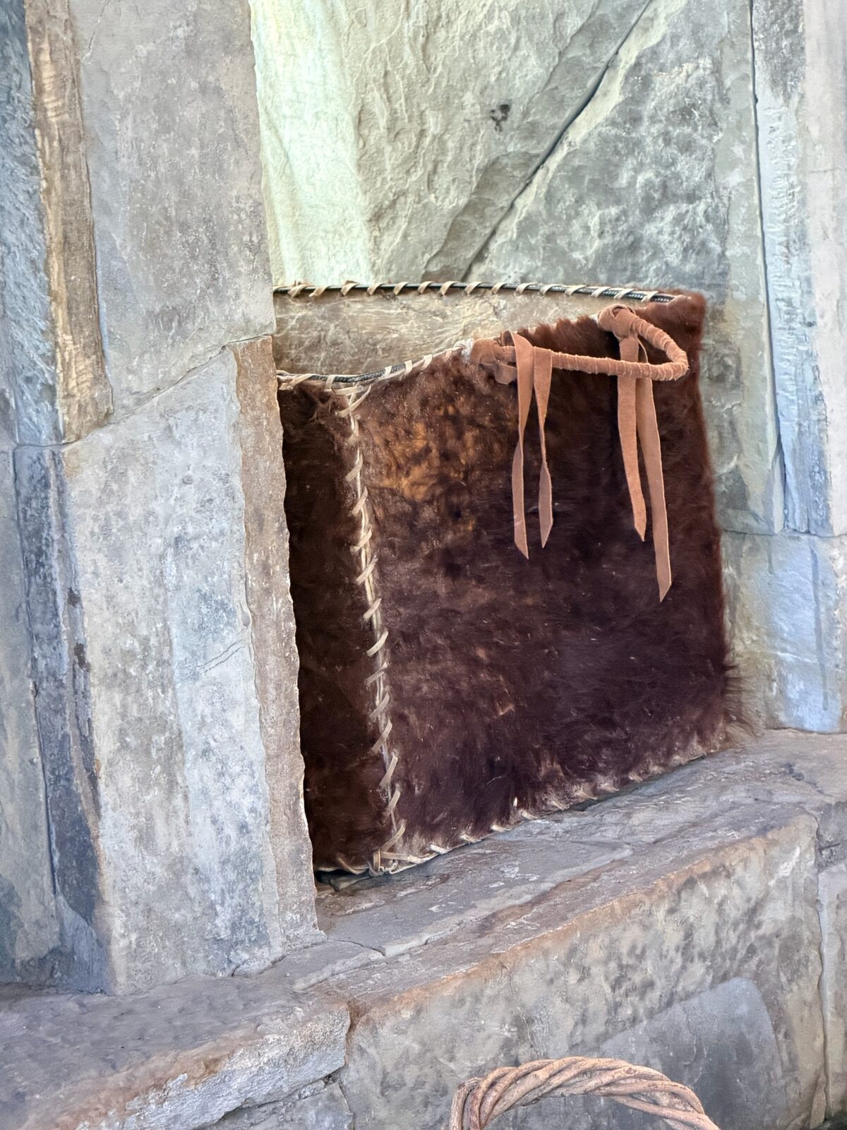 Leñero de cuero junto al hogar de piedra