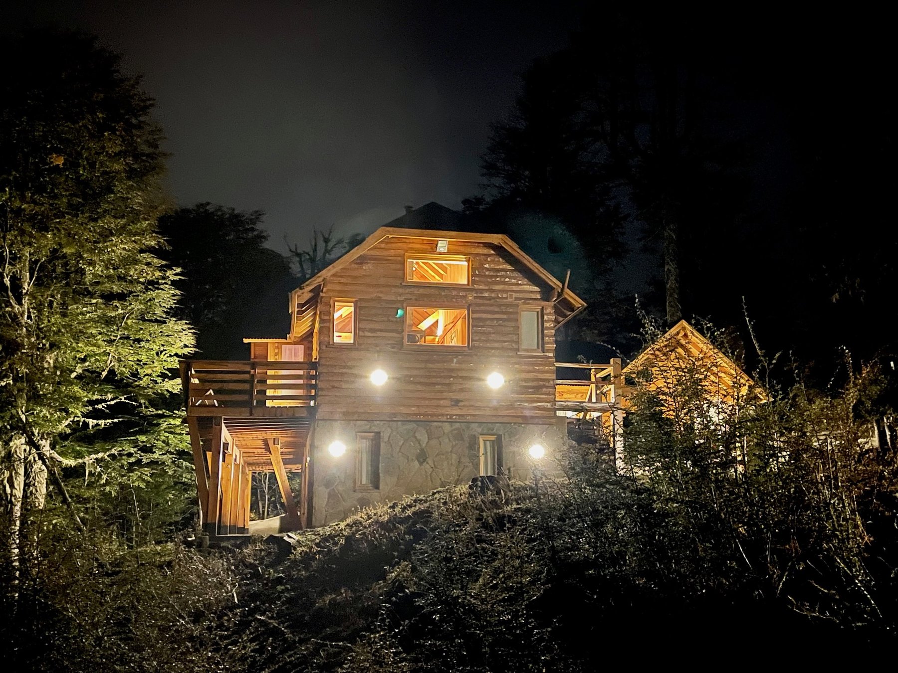 La cabaña iluminada en la noche del bosque