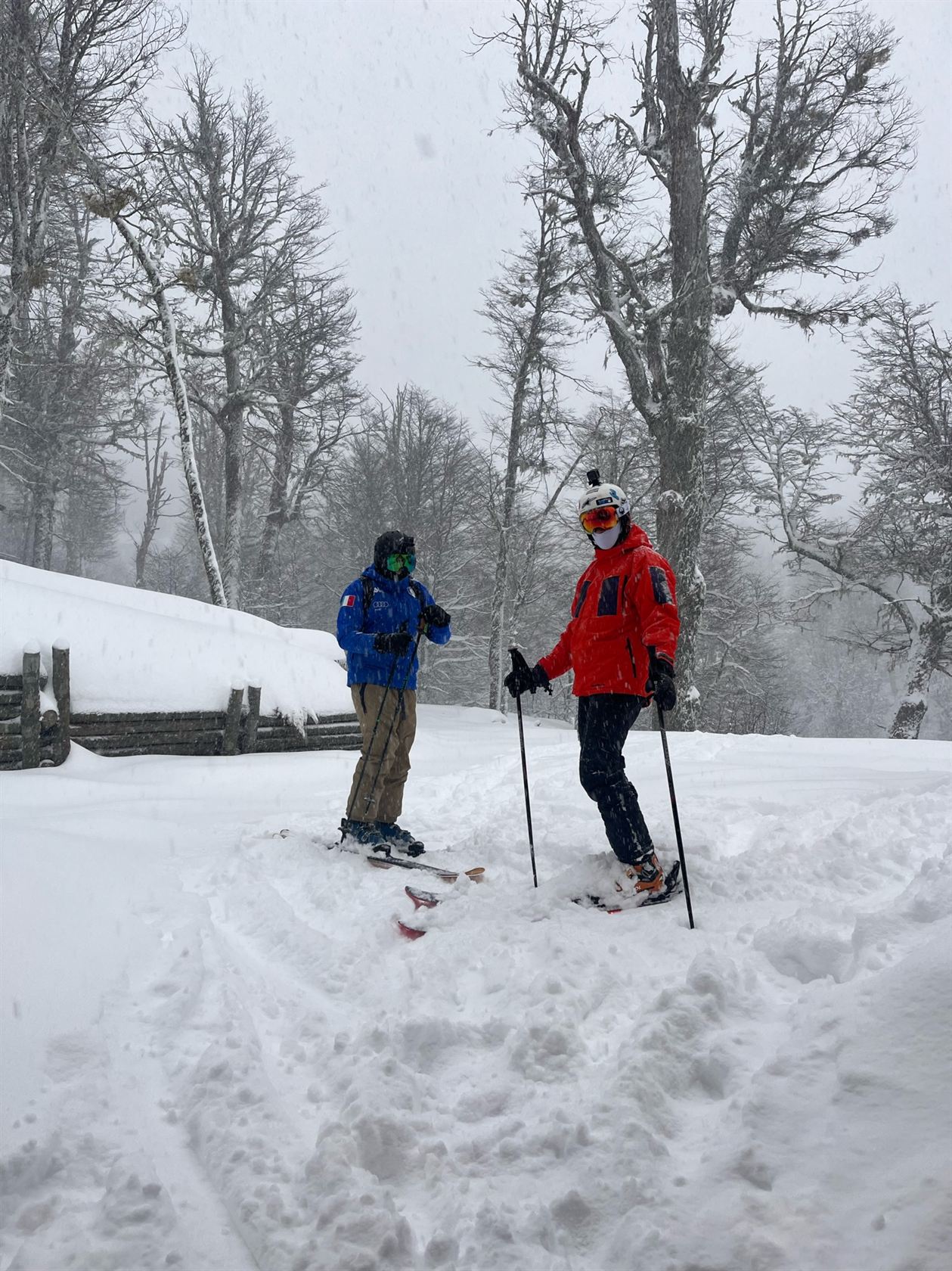 Dos esquiadores calzados junto a la casa mientras nieva: acá se sale esquiando desde la puerta